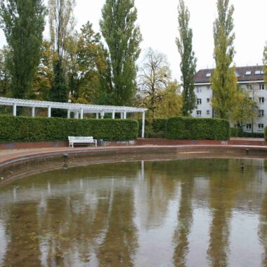 Grünanlage mit zwei gesockelten Kindergruppen und Springbrunnen